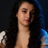 A portrait of a beautiful young woman posing for a photo against a black background